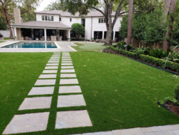 beautiful backyard with artificial grass and pavers - golf green
